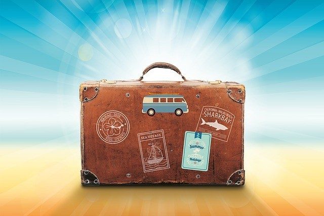 luggage stood up with travel stickers on the side