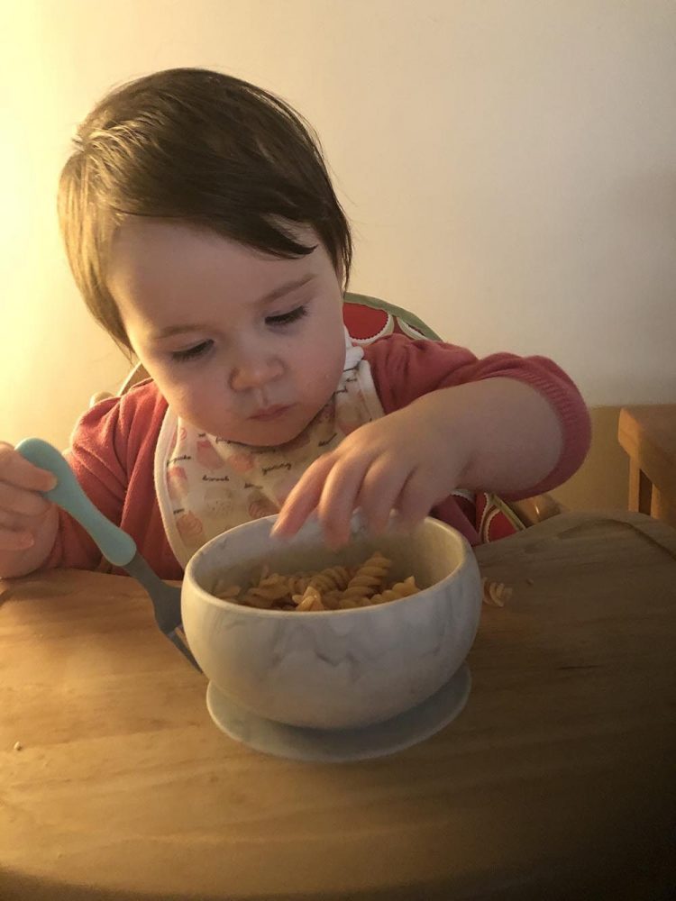 Lottie eating pasta from her grey marble effect bowl