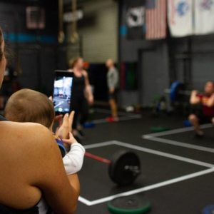 Mum holding baby while working out